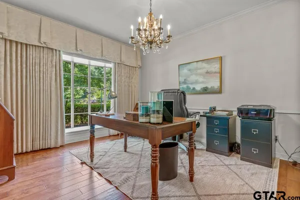 a view of a workspace with furniture and a window
