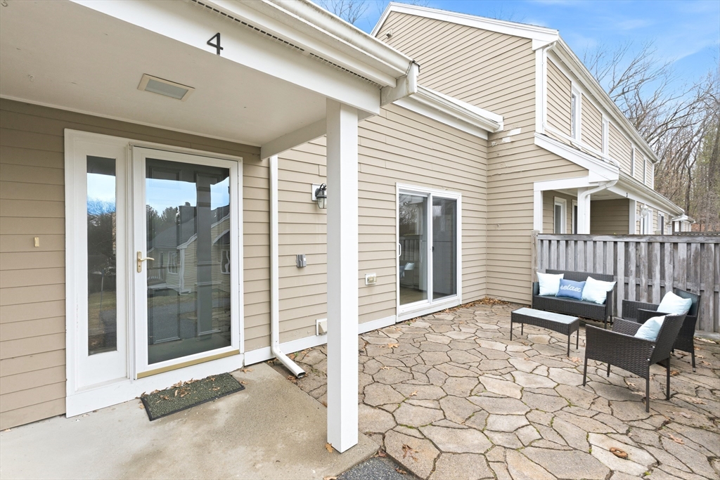 a view of a chair and table in the back yard of the house