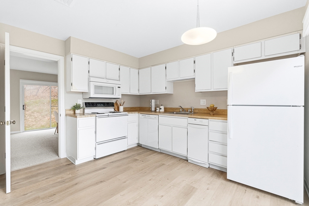 4 Drummer Boy Way, Unit 4 Lexington, MA 02420 - Photo 13 of 37 a kitchen with granite countertop white cabinets and white appliances