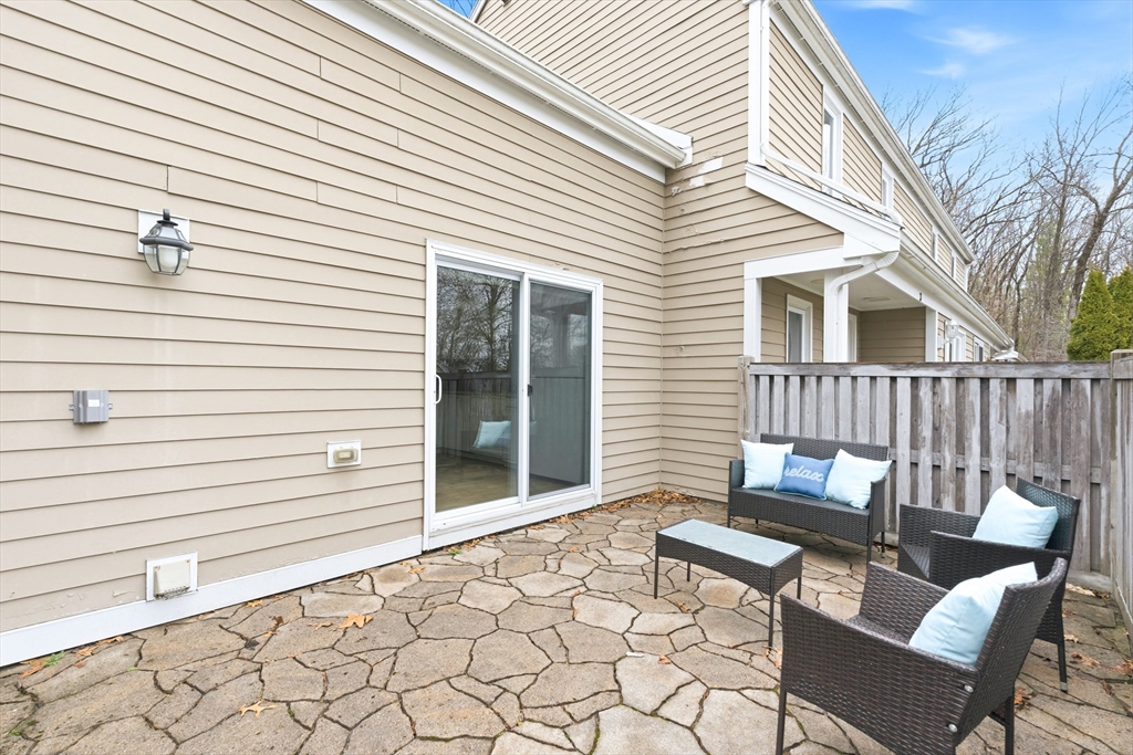 4 Drummer Boy Way, Unit 4 Lexington, MA 02420 - Photo 17 of 37 a view of a patio with a table and chairs and a barbeque with wooden fence