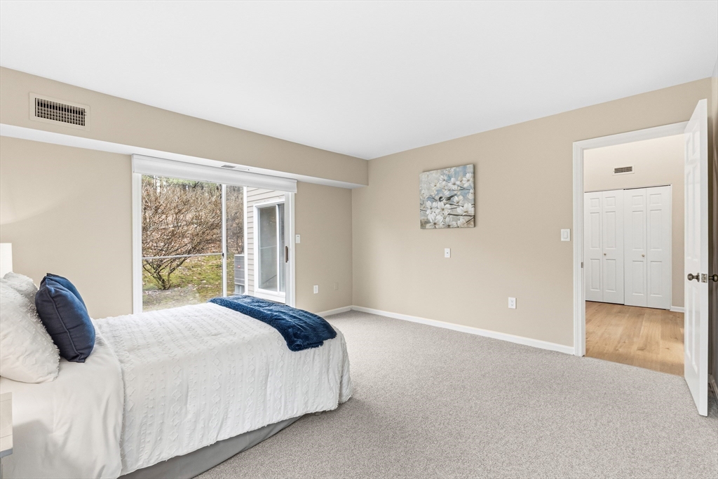 4 Drummer Boy Way, Unit 4 Lexington, MA 02420 - Photo 20 of 37 a bedroom with a large bed and wooden floor