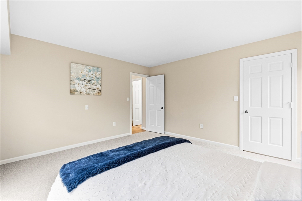 4 Drummer Boy Way, Unit 4 Lexington, MA 02420 - Photo 21 of 37 a bedroom with a bed and a painting on the wall