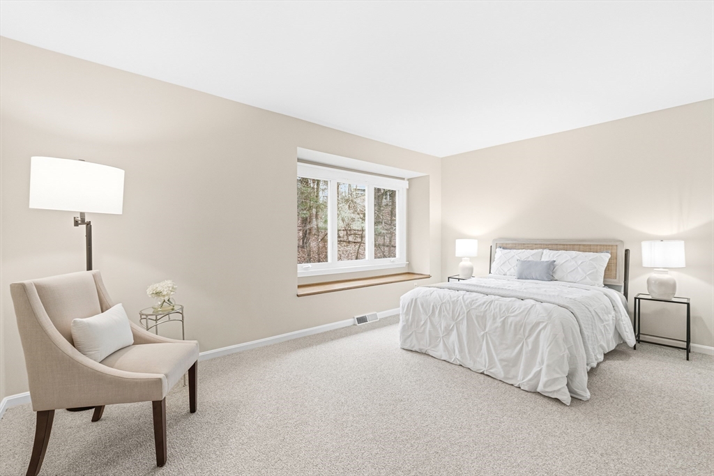 4 Drummer Boy Way, Unit 4 Lexington, MA 02420 - Photo 28 of 37 a spacious bedroom with a bed and a chair