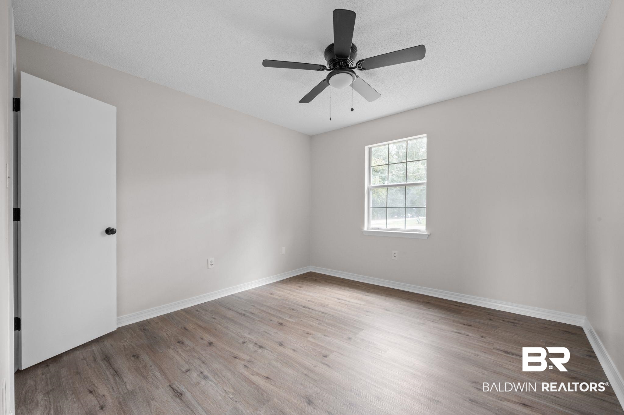 811 East Verbena Avenue Foley, AL 36535 - Photo 5 of 16 Spare room featuring ceiling fan, light wood-type flooring, and a textured ceiling