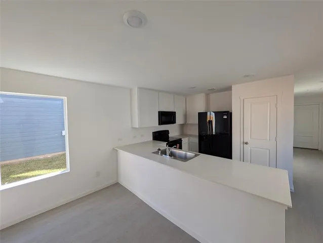 a kitchen with granite countertop a sink stove and refrigerator