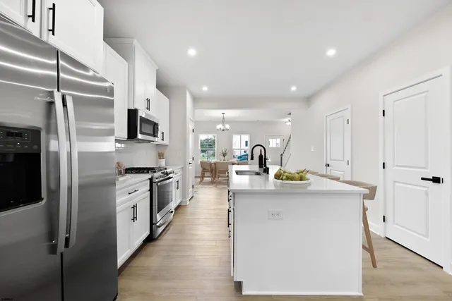 a kitchen with stainless steel appliances granite countertop a sink a stove and a refrigerator