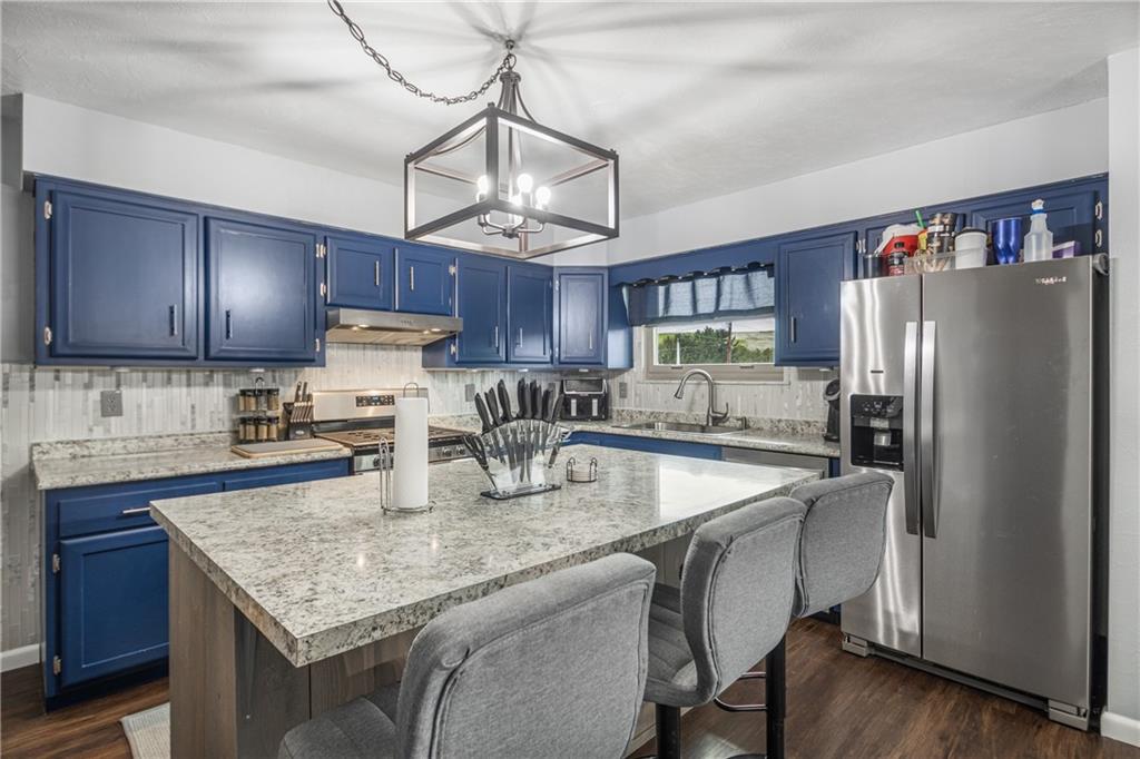 7 Josephine Street Slovan, PA 15078 - Photo 4 of 26 a kitchen with stainless steel appliances granite countertop a table chairs refrigerator and microwave
