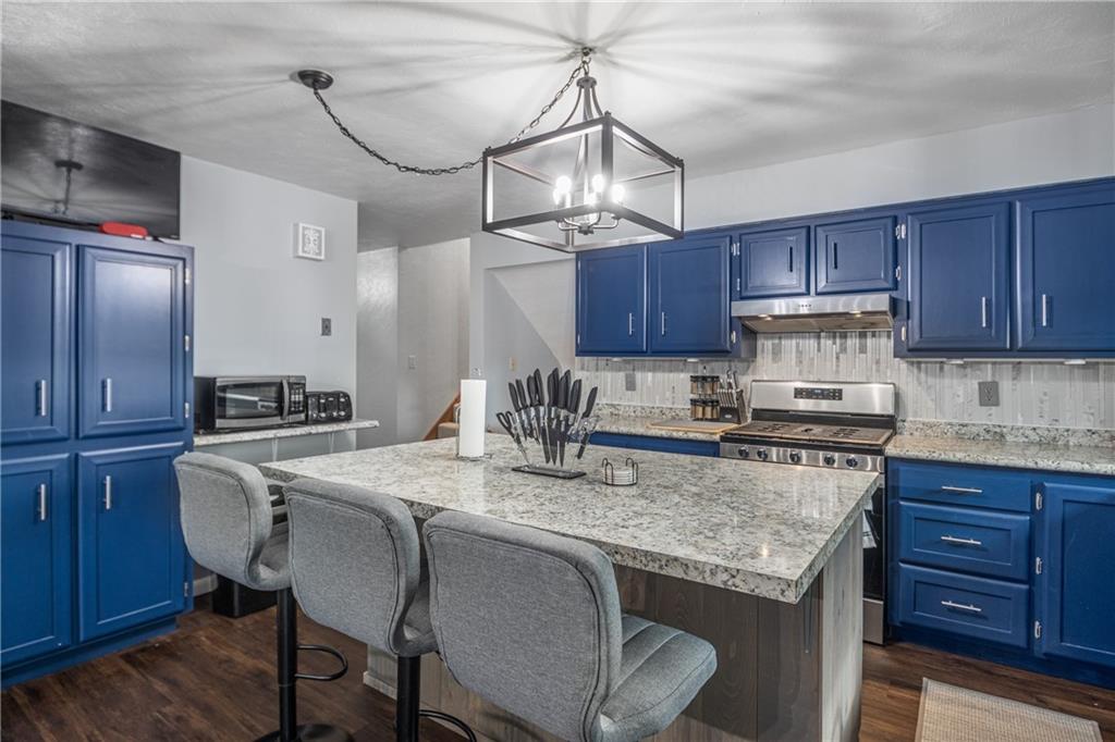 7 Josephine Street Slovan, PA 15078 - Photo 5 of 26 a kitchen with stainless steel appliances granite countertop a stove a refrigerator a sink a dining table and chairs with wooden floor