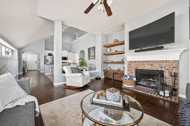 a living room with furniture a flat screen tv and a fireplace