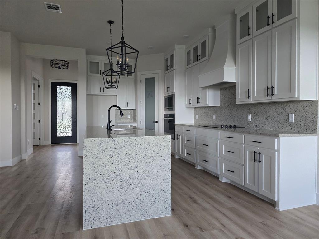808 N Avenue East Springtown, TX 76082 - Photo 4 of 21 a kitchen with stainless steel appliances granite countertop a sink a stove and a wooden floors