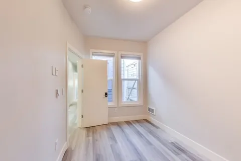 a view of a room with wooden floor and a ceiling fan