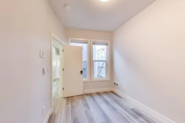 a view of a room with wooden floor and a ceiling fan