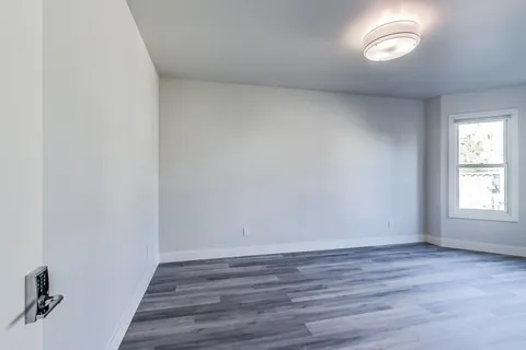 an empty room with wooden floor and white walls