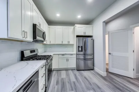 a bedroom with a bed and a view of living room
