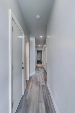 a bedroom with a bed a chair and next to a window