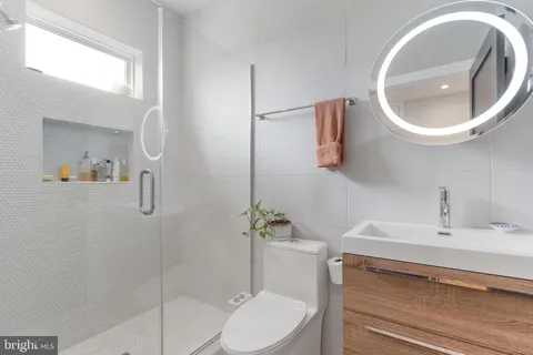 a bathroom with a sink a toilet and a mirror