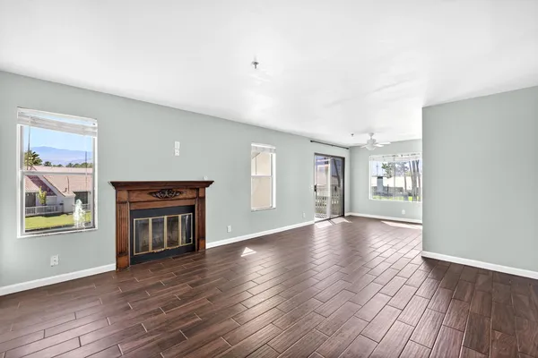 a view of an empty room with window and wooden floor