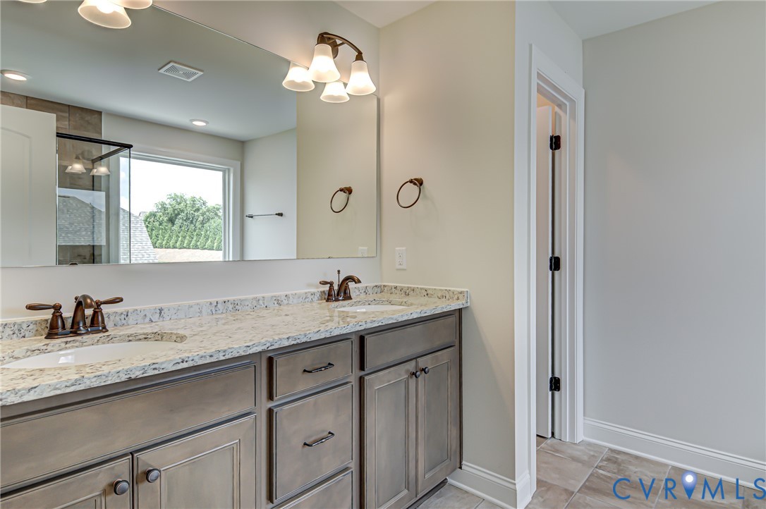 11366 Pinewild Drive Providence Forge, VA 23140 - Photo 12 of 22 a bathroom with a granite countertop sink a light fixture and a mirror