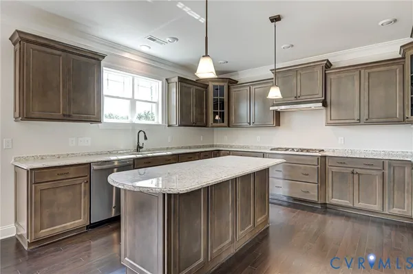 a kitchen with stainless steel appliances granite countertop a sink a stove a refrigerator and island with wooden floor