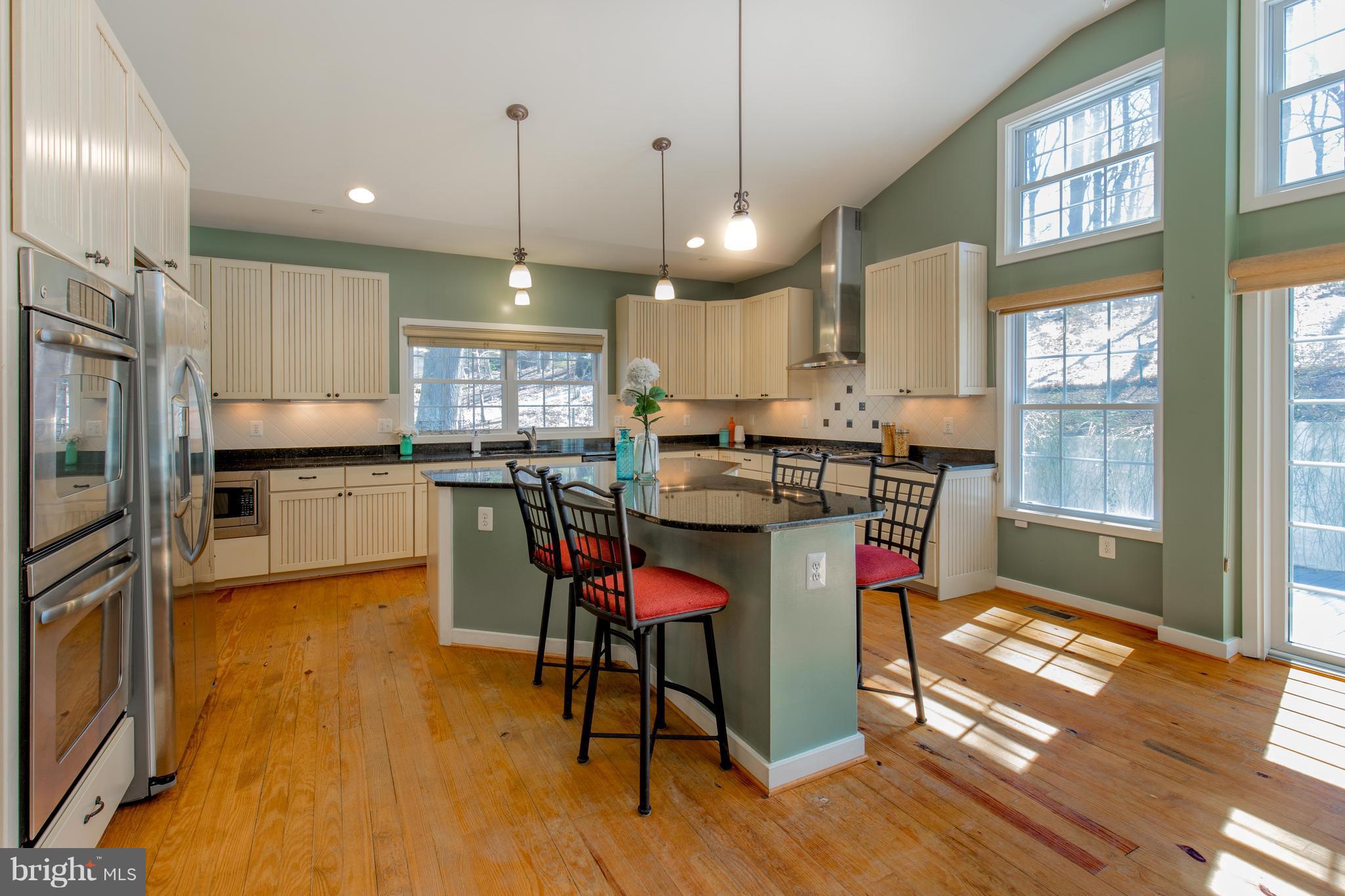 309 Willington Drive Silver Spring, MD 20904 - Photo 12 of 30 a kitchen with stainless steel appliances a dining table chairs stove refrigerator and cabinets