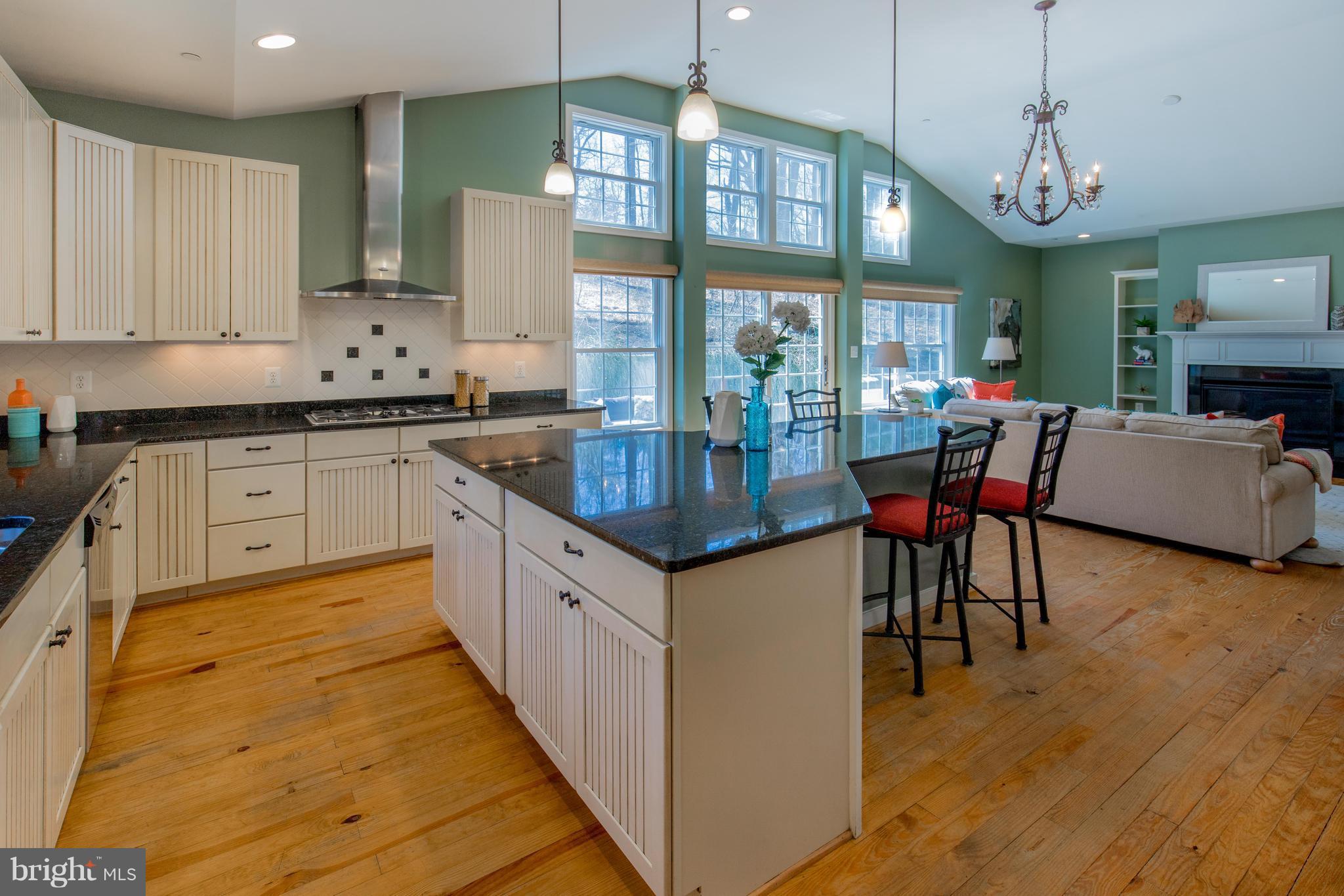 309 Willington Drive Silver Spring, MD 20904 - Photo 13 of 30 a kitchen with granite countertop a stove a sink a dining table and chairs with wooden floor