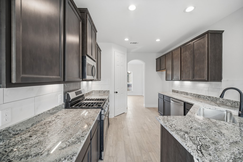 16507 Boston Post Road Cypress, TX 77429 - Photo 13 of 39 The kitchen features granite countertops, recessed lighting, rich brown cabinetry, and a convenient pantry.