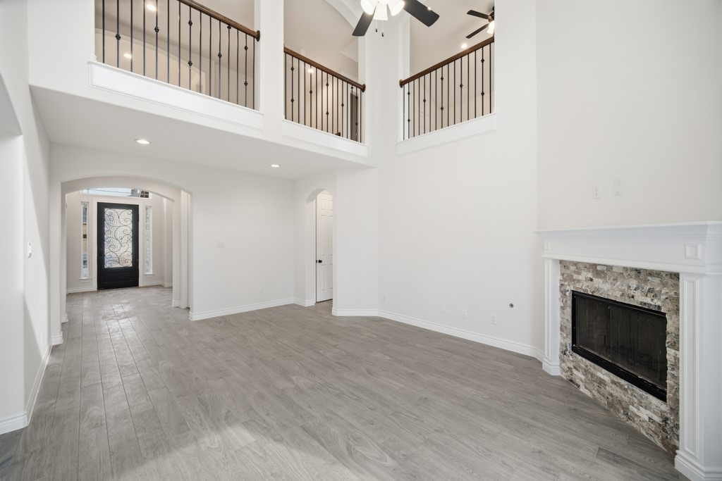 16507 Boston Post Road Cypress, TX 77429 - Photo 9 of 39 Tile flooring extends from the entry into the family room, creating a seamless, open flow. The upstairs overlook highlights the home’s spacious and airy design.