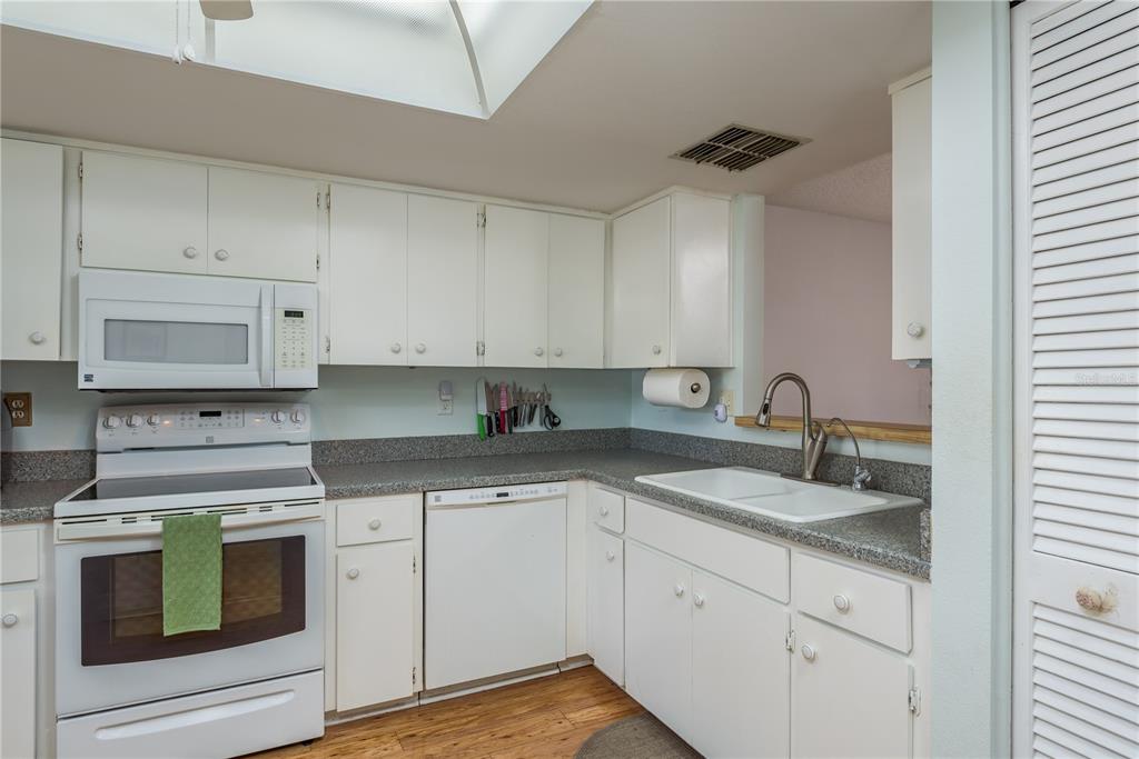 11241 Dollar Lake Drive, Unit 5 Port Richey, FL 34668 - Photo 13 of 49 a kitchen with granite countertop white cabinets white stainless steel appliances with a sink and dishwasher