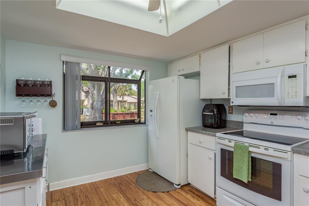 11241 Dollar Lake Drive, Unit 5 Port Richey, FL 34668 - Photo 14 of 49 a kitchen with stainless steel appliances a stove sink and microwave