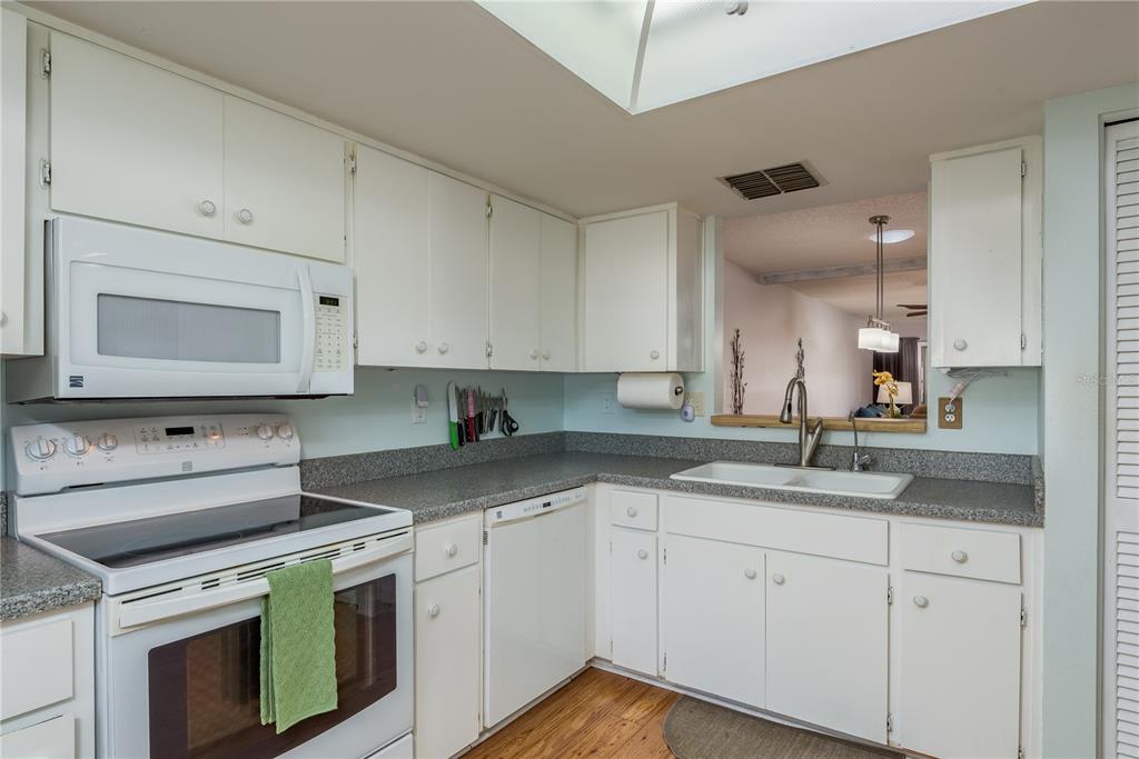 11241 Dollar Lake Drive, Unit 5 Port Richey, FL 34668 - Photo 15 of 49 a kitchen with white cabinets sink and stove