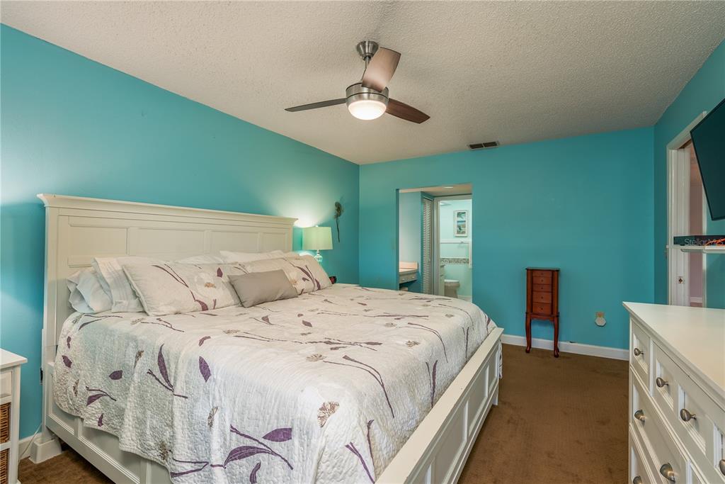 11241 Dollar Lake Drive, Unit 5 Port Richey, FL 34668 - Photo 17 of 49 a bedroom with a large bed and a chandelier