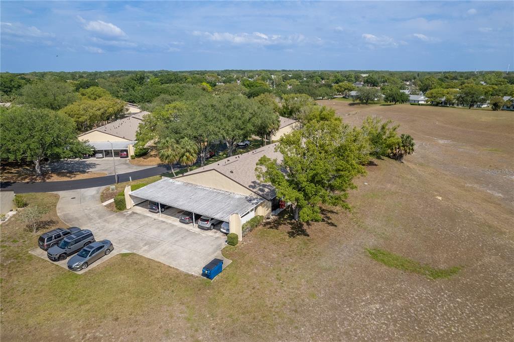 11241 Dollar Lake Drive, Unit 5 Port Richey, FL 34668 - Photo 31 of 49 an aerial view of a house with a garden and lake view