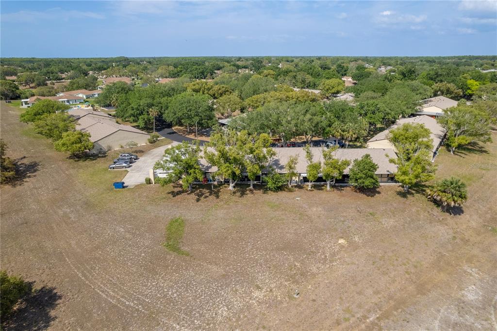 11241 Dollar Lake Drive, Unit 5 Port Richey, FL 34668 - Photo 34 of 49 an aerial view of a houses with a yard and lake view