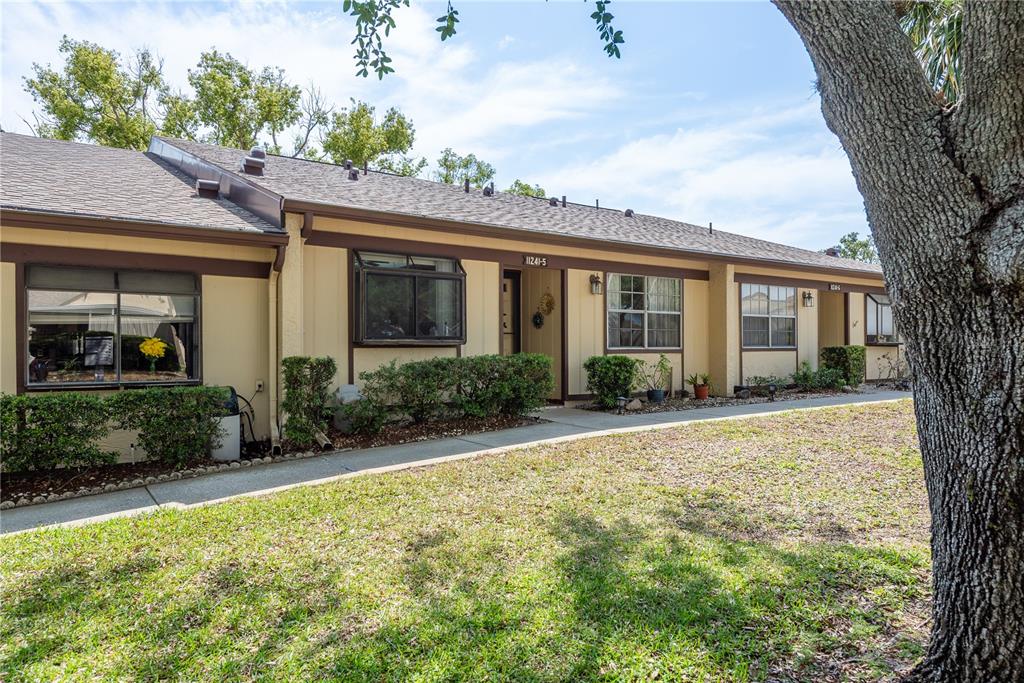 11241 Dollar Lake Drive, Unit 5 Port Richey, FL 34668 - Photo 4 of 49 a front view of a house with garden