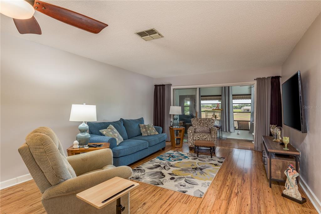 11241 Dollar Lake Drive, Unit 5 Port Richey, FL 34668 - Photo 7 of 49 a living room with furniture and a flat screen tv