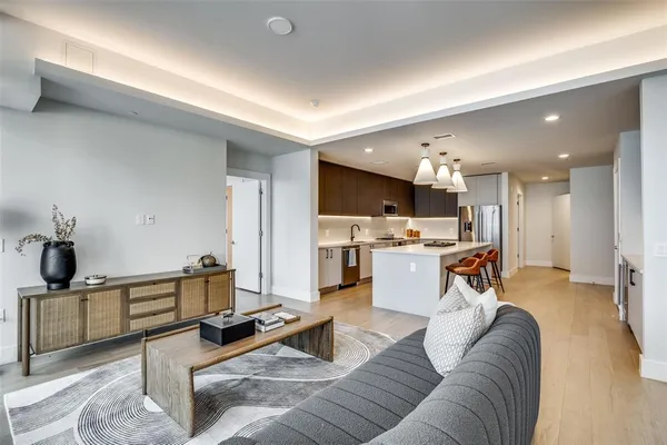 a living room with furniture and view of kitchen