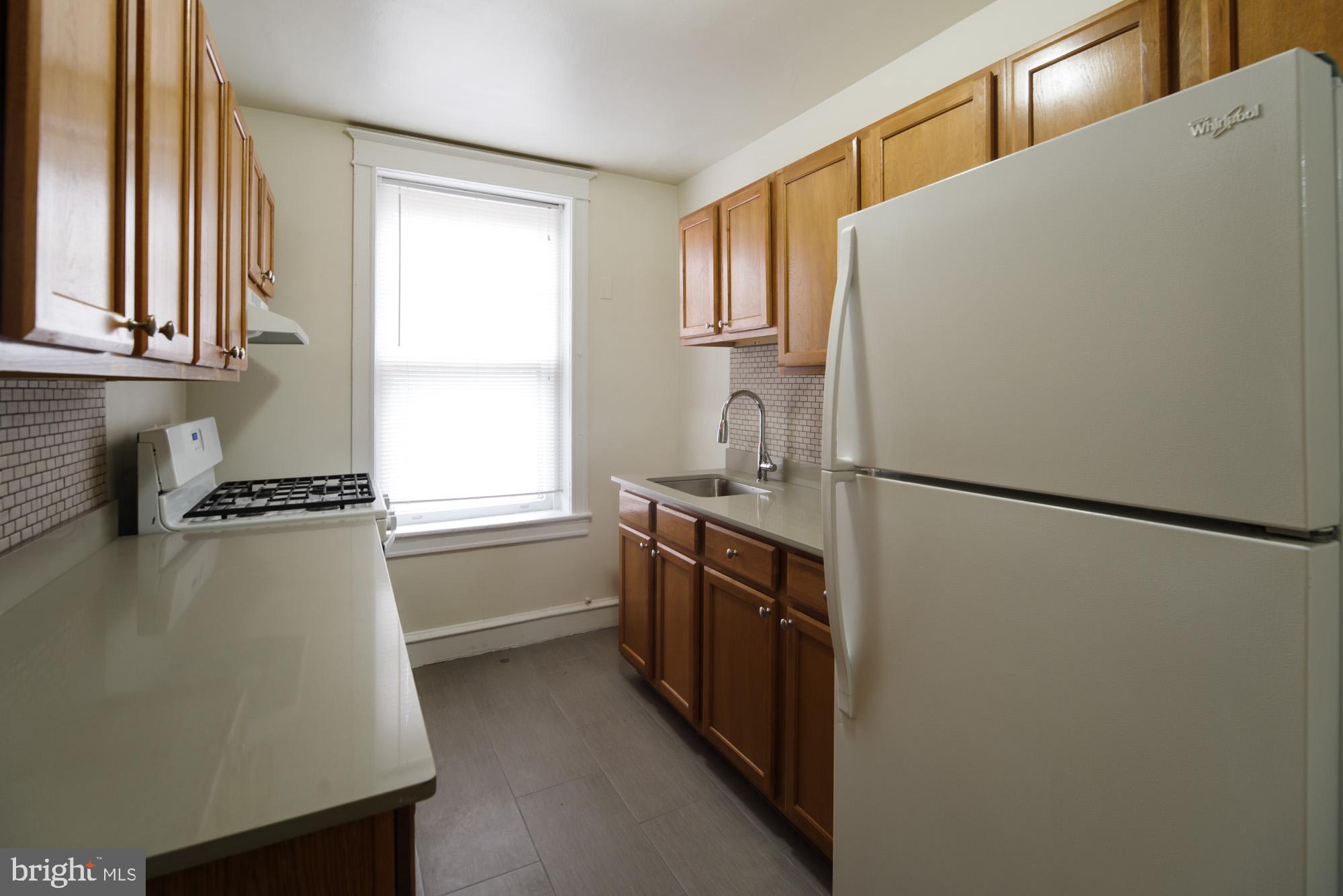 6640 Sprague Street, Unit A302 Philadelphia, PA 19119 - Photo 12 of 13 a kitchen with a refrigerator and a sink