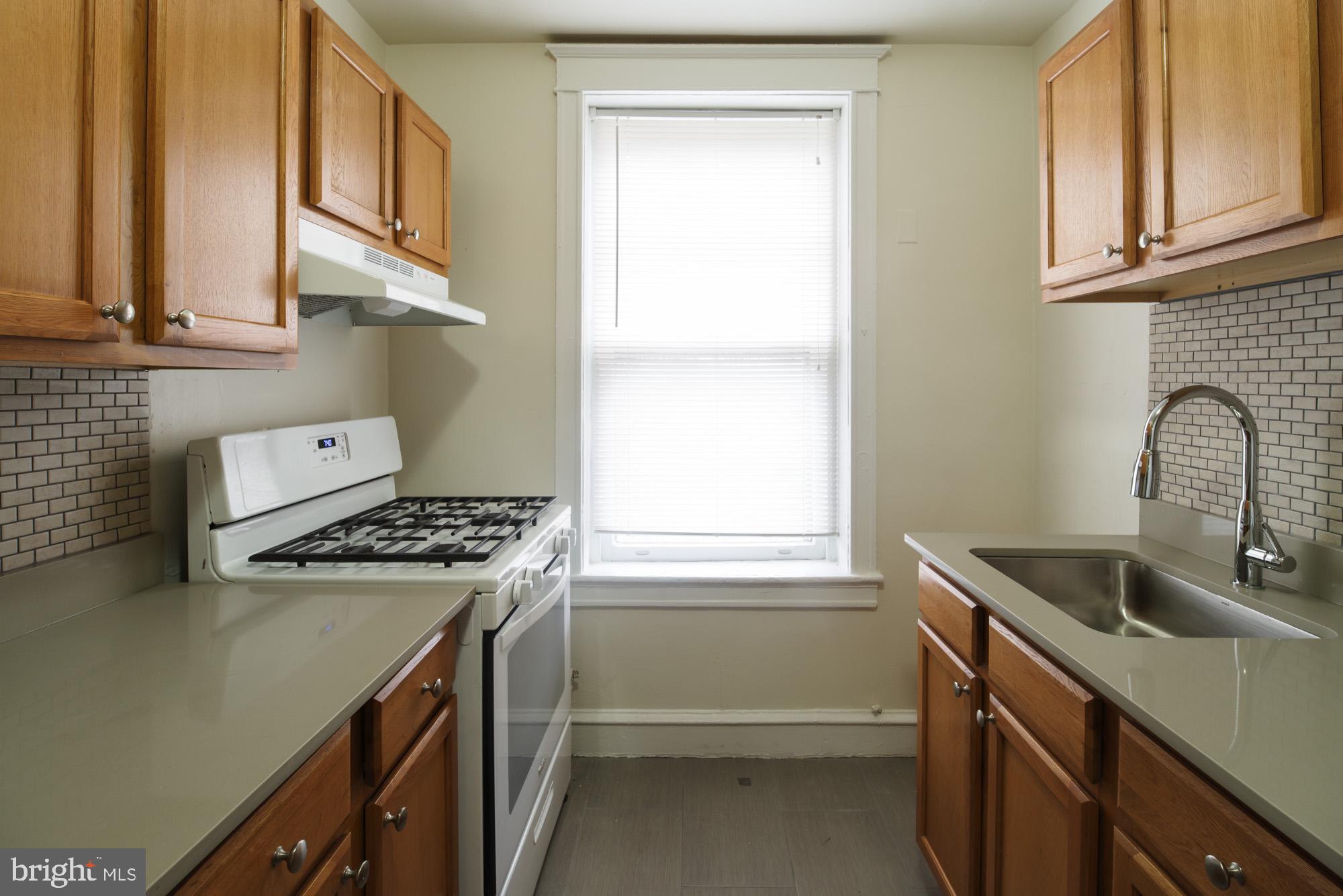 6640 Sprague Street, Unit A302 Philadelphia, PA 19119 - Photo 13 of 13 a kitchen with granite countertop a sink stove and cabinets