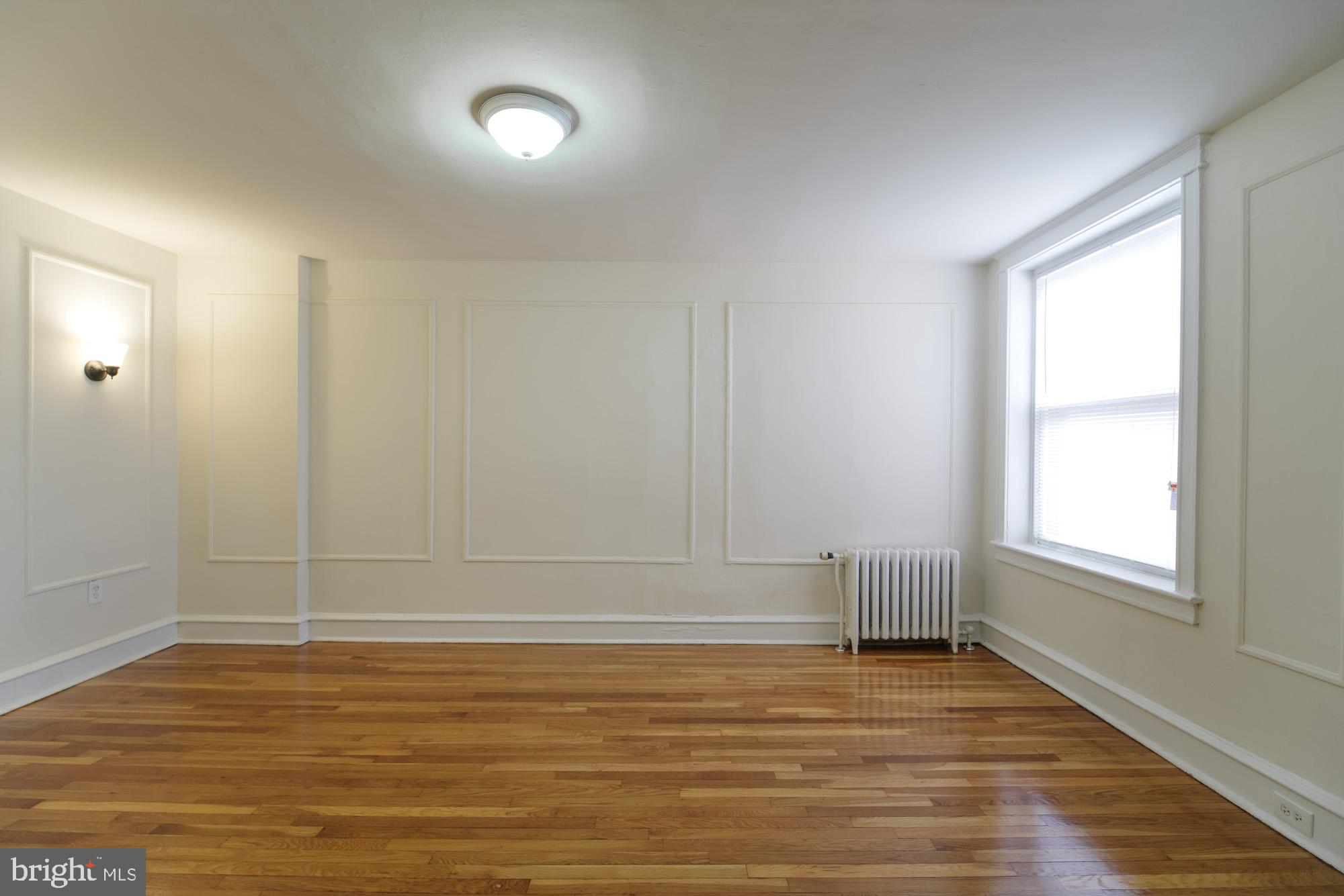 6640 Sprague Street, Unit A302 Philadelphia, PA 19119 - Photo 3 of 13 wooden floor in an empty room with a window
