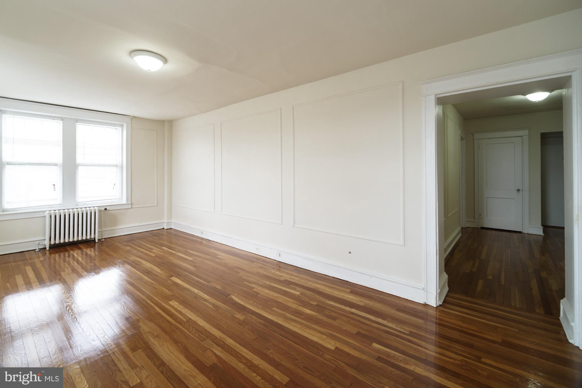 6640 Sprague Street, Unit A302 Philadelphia, PA 19119 - Photo 8 of 13 wooden floor in an empty room with a window