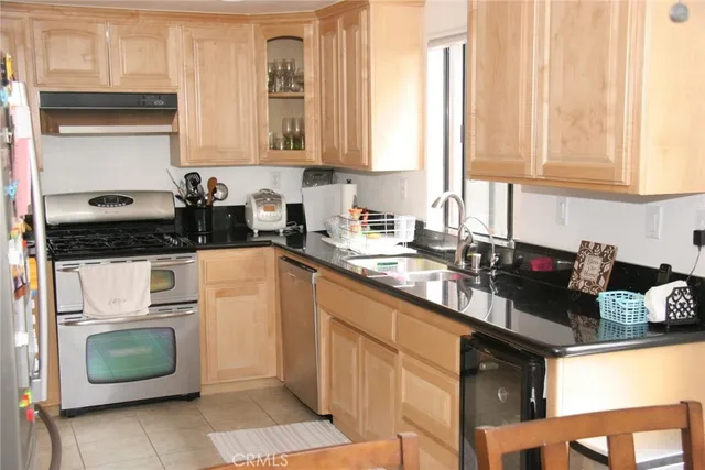 a kitchen with granite countertop a sink stainless steel appliances and cabinets