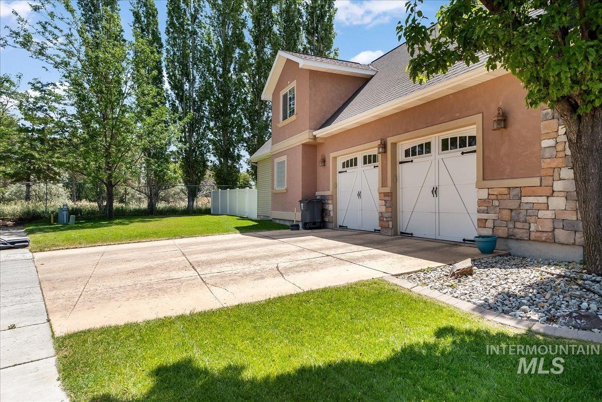 1111 Cole Street Kimberly, ID 83341 - Photo 4 of 49 View of property exterior featuring concrete driveway, stucco siding, an attached garage, and roof with shingles
