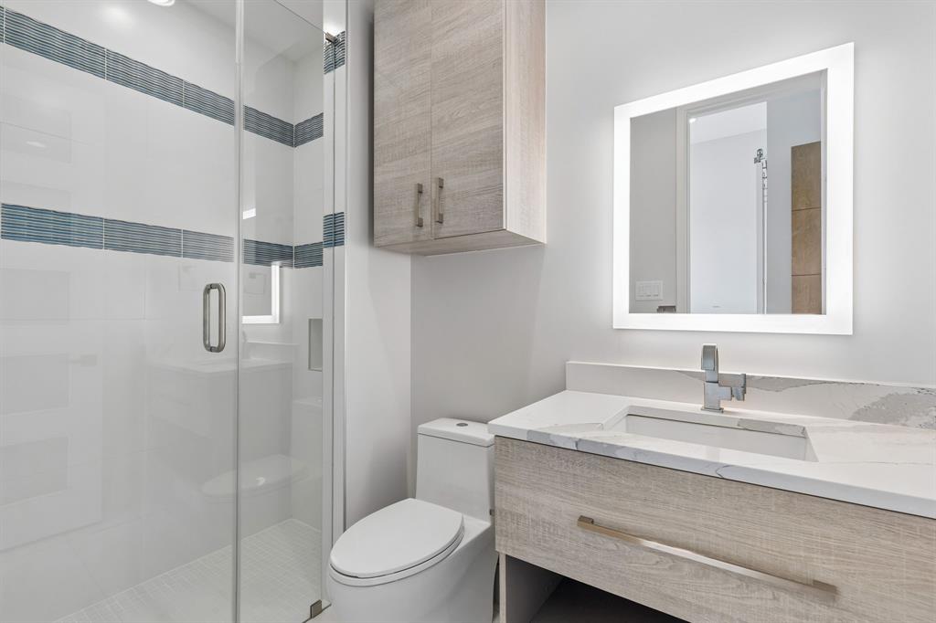 548 Oak Grove Lane Coppell, TX 75019 - Photo 24 of 36 a bathroom with a granite countertop sink a toilet and shower