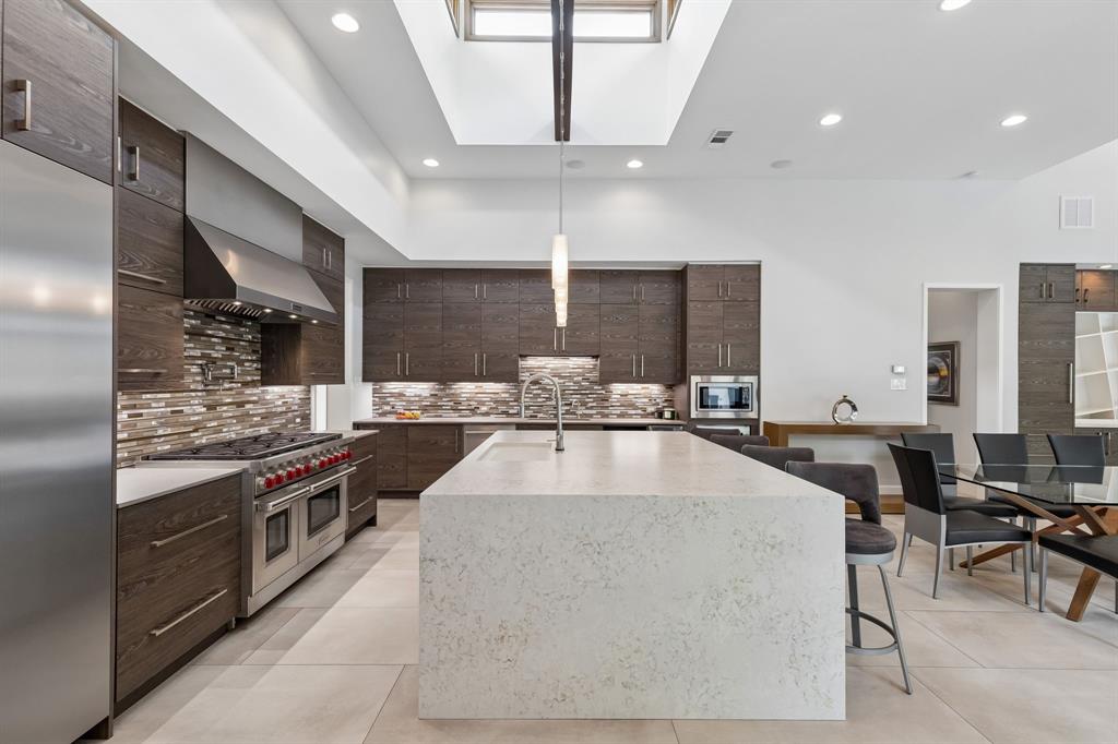 548 Oak Grove Lane Coppell, TX 75019 - Photo 7 of 36 a large kitchen with stainless steel appliances kitchen island granite countertop a table chairs in it and wooden floors