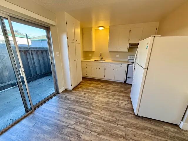 a view of a kitchen with wooden floor and electronic appliances