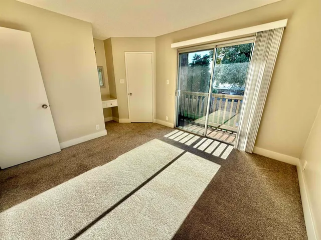 a view of a bedroom with wooden floor and windows