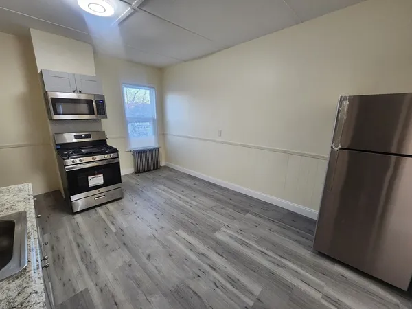 a kitchen with a refrigerator and a stove top oven