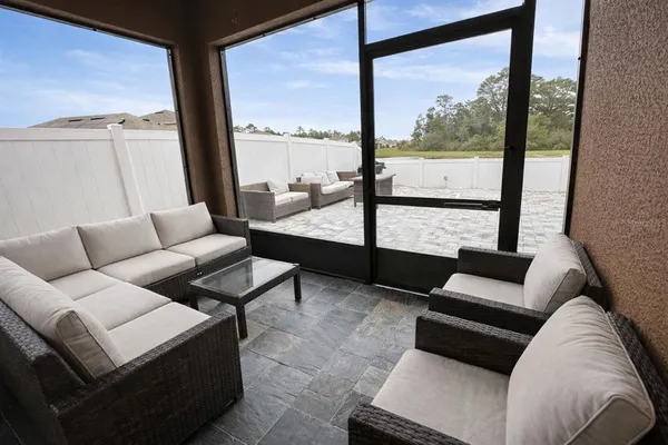 a living room with furniture and a floor to ceiling window
