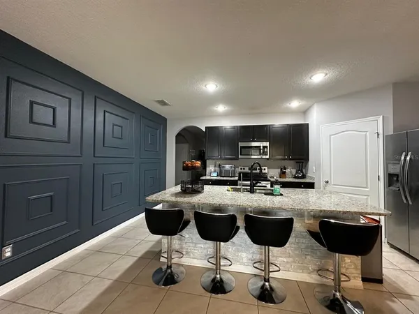 a kitchen with refrigerator cabinets and chairs