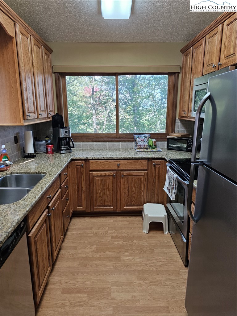 109 Foxgrape Hollow Road Beech Mountain, NC 28604 - Photo 8 of 50 a kitchen with stainless steel appliances granite countertop sink microwave and window